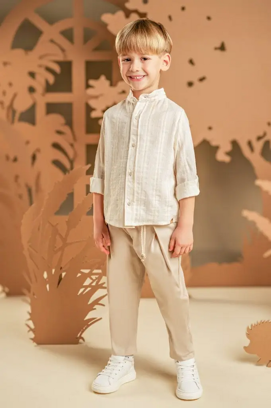 Ένα χαλαρό και casual look για αυτούς που προτιμάνε μια καλοκαιρινή εμφάνιση.  Το σετ αποτελείται από παντελόνι βαμβακερό σε μπεζ χρώμα και πουκάμισο σε εκρού-μπεζ  υφαντό ύφασμα με Μάο γιακά. Το σύνολο ολοκληρώνεται με το εμπριμέ φλοράλ φουλάρι