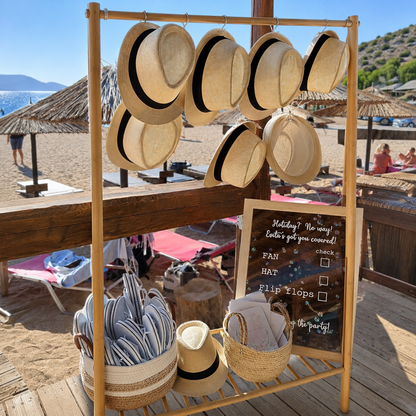 Boho beach wedding decoration at sunset with wooden aisle, floral arches and lanterns in Athens, Greece.