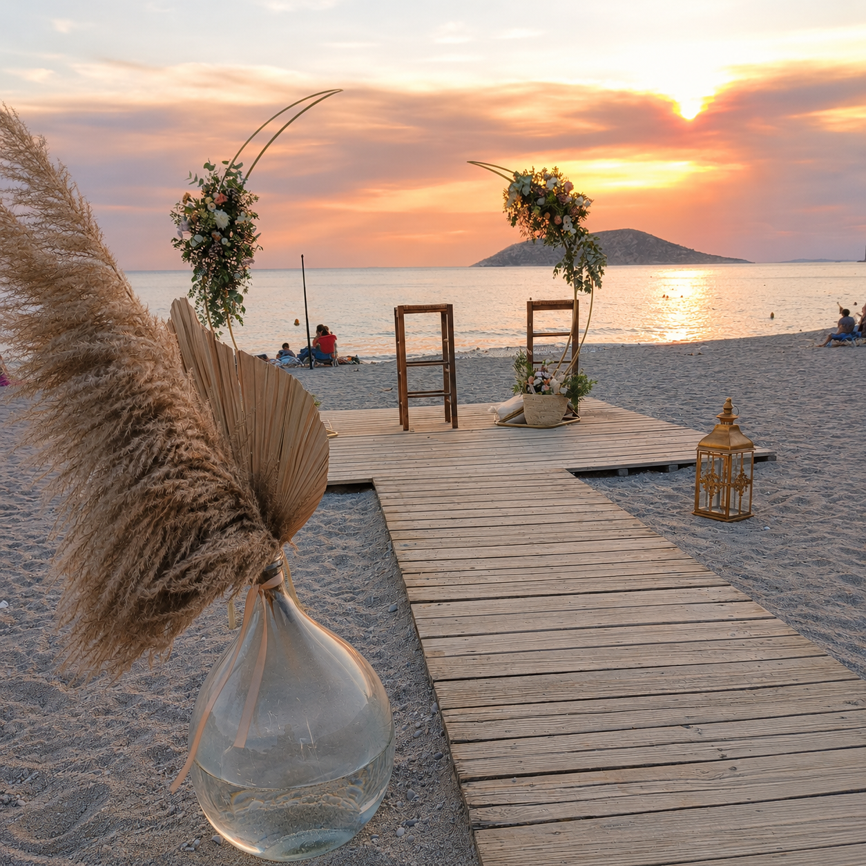 Boho beach wedding decoration at sunset with wooden aisle, floral arches and lanterns in Athens, Greece.